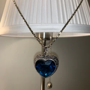 Accessoarer  - Ett fint halsband med en blå Sten/hjärta med en lång kedja, har aldrig haft på den. FRI FRAKT