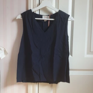 Blå blus med prickar - Super gulligt blus från Lindex Holly&Whyte. V-formad urringning. Små prickar på. Snygg vikning i ryggen som man ser på andra bilden. Hör av dig vid intresse eller vill ha fler bilder☀️🌊