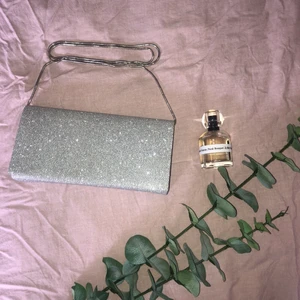 Glittrig kuvert/crossover  - Supersnygg väska endast använd en gång på min studentbal. Hoppas den kan komma till mer användning hos någon annan. Köpte den för 399 kr från Tiamo. Den har ett axelband men går att ta av. Frakt tillkommer. 