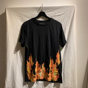 T-shirt med flammor - T-shirt med flammor från carlings. Använts enstaka gånger och är i bra skick. Säljs då den inte används. 
