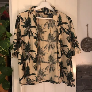 Skjorta med palmer storlek M - Använd två gånger köpt förra sommaren och inte använd sen dess! Frakten är inräknad i priset.