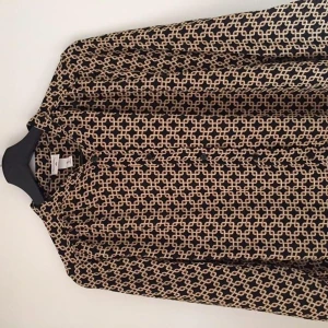 Lång skjorta/ blus med mönster - Säljer denna långa blusen med häftigt mönster från H&Ms kollektion med Richard Allan. Den är nyköpt men aldrig kommit till användning. ❤