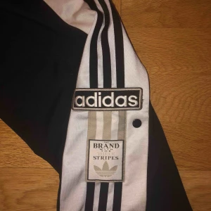  - Snygga svarta adidas byxor med knappar i bra skick.