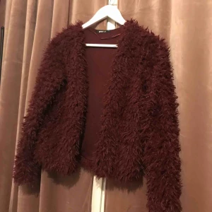  - Snygg och trendig pälsjacka som också går att använda som kofta eller kavaj, vinröd/ lila i färgen och glittrar på nära håll i tyget. Sparsamt använd✨