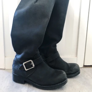 Boots från URBAN PROJECT - Knähöga boots från Urban Project, med spänne över ankeln och dragkedja baktill. Storlek 37, men passar 38 (jag är en 38 i vanliga fall). Sparsamt använda. 
