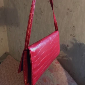 Röd baugettväska  - Jag säljer min väska som jag köpte secondhand i somras💗 Jag har bara använt den två gånger och känner att jag inte har användning för den längre. Jag vet tyvärr inte vilket märke det är(: Köparen står för frakten eller så möts vi upp i Stockholm.  ✨Buda i kommentarerna eller få den direkt för 140✨