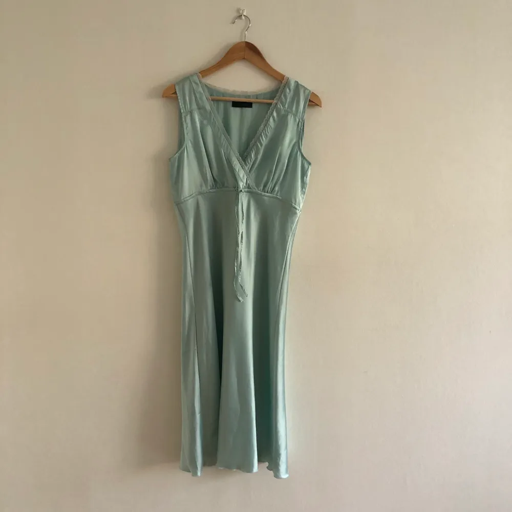 Grön/turkos underklänning med spetsdetaljer, fint skick, inga synliga skavanker. Frakt 40-60kr. Klänningar.