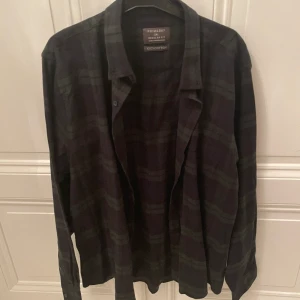 Bomullsskjorta oversized marinblå/mörkgrön  - Säljer min 100% bomullsskjorta som är supermysig och jättefin. Storleken är 2XL, sitter oversized. Kompletterar verkligen din outfit! Skjortan är i rutigt mönster med färgen marinblå/mörkgrön. Aldrig använd! 