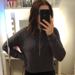 Mörkgrå hoodie - Mörkgrå hoodie från Bik bok, kortare modell. Har en dragkedja, luva och snören. Stl XS. Sälj pga att jag inte använder den längre. 