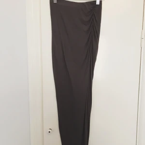  - Mörkgrå maxikjol i strl XS, passar även S. Hög midja och slits på ena sidan. 