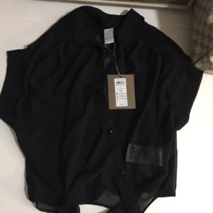  - Oanvänd topp, skjortliknande med knyte runt midjan. 349 nypris 