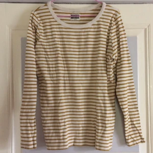  - 🐚 Snygg basic långärmadtröja med en touch! Äggskalsfärgat vit med guldish-gula ränder. Snygg instoppad i höga jeans! Storlek Small. Från Weekday MTWTFSS. 100% bomull. Köpt 2hand, fint skick! Vid frakt: +45kr 🐚