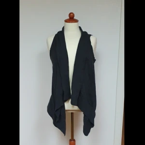 Mörk grå väst - Snygg grå tajtstickad väst. Jätte skön och en bra accesoar till jeans och ett linne.