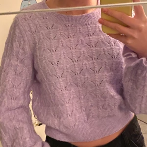 Stickad lila tröja  - Stickad jätte från lila tröja med volang i ärmen från and other stories. Hyfsat kort i modellen. Säljer för 200kr
