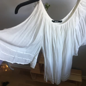 BIKBOK klänning vit - Vit klänning från BIKBOK öppen i armen. Sitter väldigt lös. Slutar precis över knäna (jag är 172 cm). 