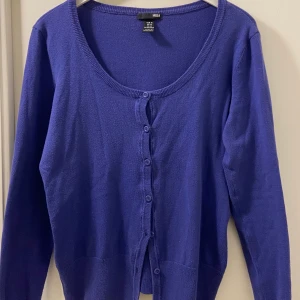 Lila U-ringad kofta - Oanvänd lila kofta köpt på second hand. Väldigt fint plagg som tyvärr inte passade mig. Köparen står för frakten 💜