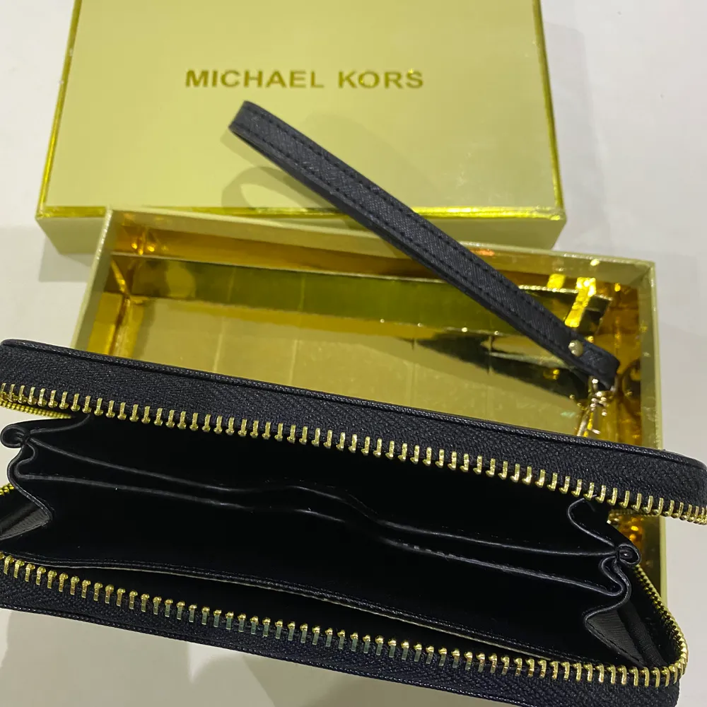 Helt ny Michael Kors plånbok med guldnitar på. Säljer den för att jag redan har en plånbok jag trivs med. . Väskor.