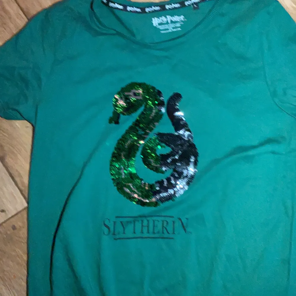 En snygg tröja med slytherin loggan på.. T-shirts.