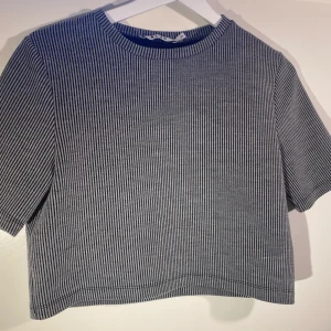 Cropad top - Grå svart randig top från nakd i ganska tjockt material. Inte jättekort men ändå lite cropped.
