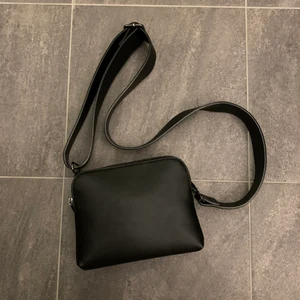 Väska - Väska med bredare band och två fack.