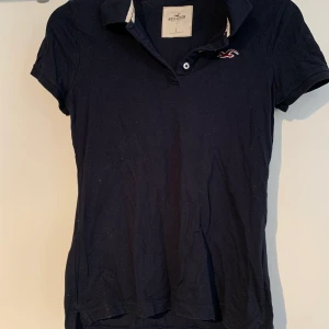 Hollister pike - Mörkblå piké från hollister, väldigt sparsamt använd.  Frakt tillkommer. 