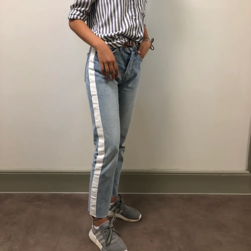 Säljer dessa otroligt snygga mom jeans med en vit stripe på varsinn sidan i mycket bra skick🤩 Stl 34. Pris 300kr:). Jeans & Byxor.