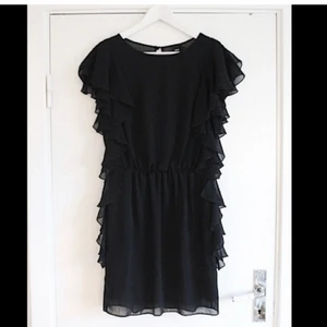 Klänning från Asos - Så snygg svart klänning i chiffong med volanger och öppen rygg från ASOS! Sitter så snyggt på och känns väldigt lyxig. Tyvärr har den aldrig kommit till användning så den är helt oanvänd med tags kvar. Passa på att fynda! 