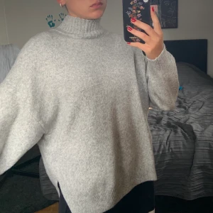 Stickad tröja - Ljusgrå stickad tröja från H&M med en lös högre krage. 