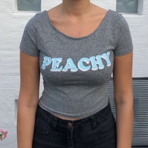 Söt croptop med printet ’PEACHY’ stl. s - Söt grå croptop med printet ’Peachy’ 🍑.  Knappt använd, stl. s