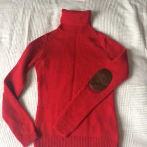  - Ull- och kashmirtröja i rött med bruna skinndetaljer på armbågarna 