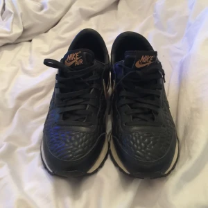  - Nästan helt oanvända Nike skor! Svarta med guld detaljer och mönstrad tå! Köparen står för frakten