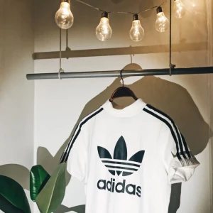  - Adidas Originals Mock Neck T-shirt. Vit/svart. Stretchigt skönt material i 80% bomull och 20% polyester. Köpt i London på JD sports för 299 kr. Använd max 5 gånger så den är i princip ny. 