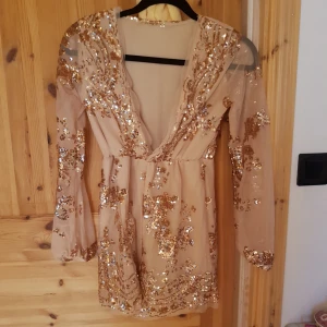  - Oanvänd playsuit i beige med lite paljetter på. Den är för liten för mig, vilket är anledningen till att jag säljer den. Jag är 169 cm lång, och tror någon mindre än mig hade passat bättre i den. Köparen står för frakt. OBS, katt i hemmet. 