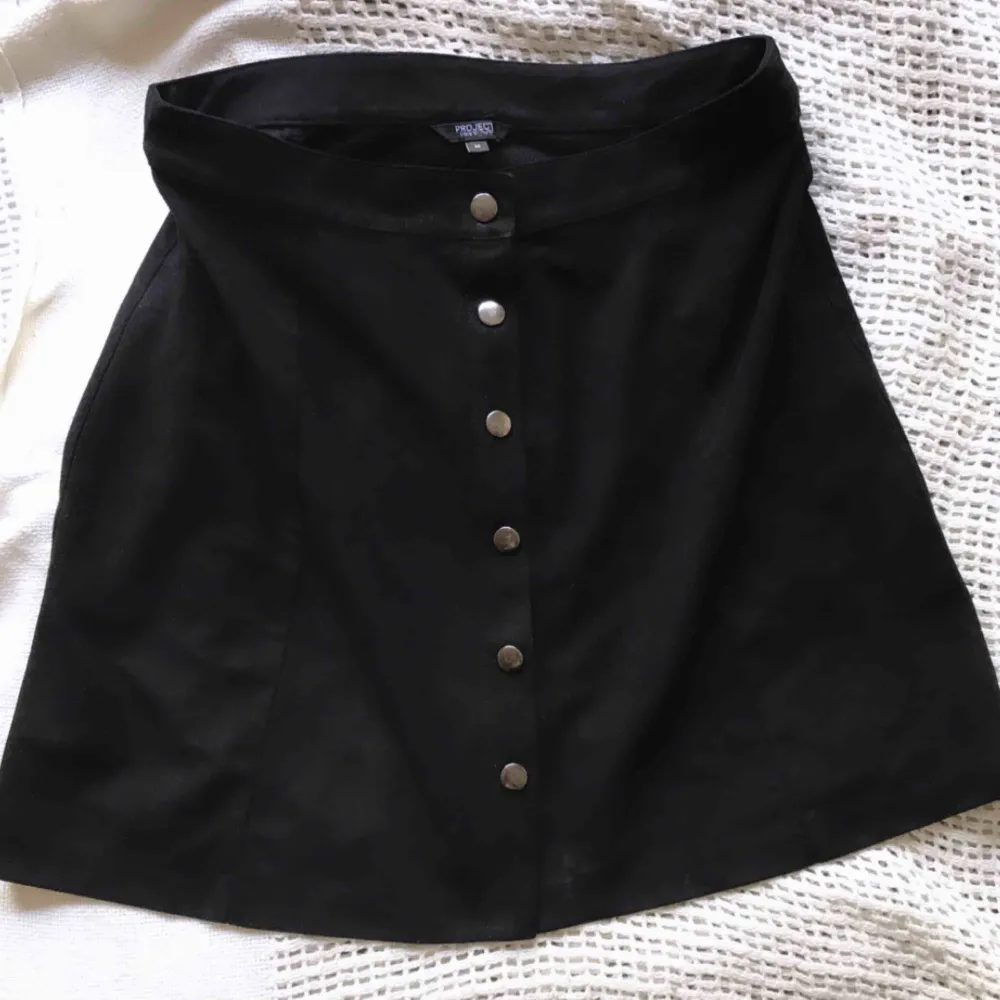 Jättefin svart kjol i skinnkaraktär med silverknappar som går att öppna! Köpt i New York. Superfin till vardag och fest! 🍸   MATERIAL: 100% Polyester . Kjolar.