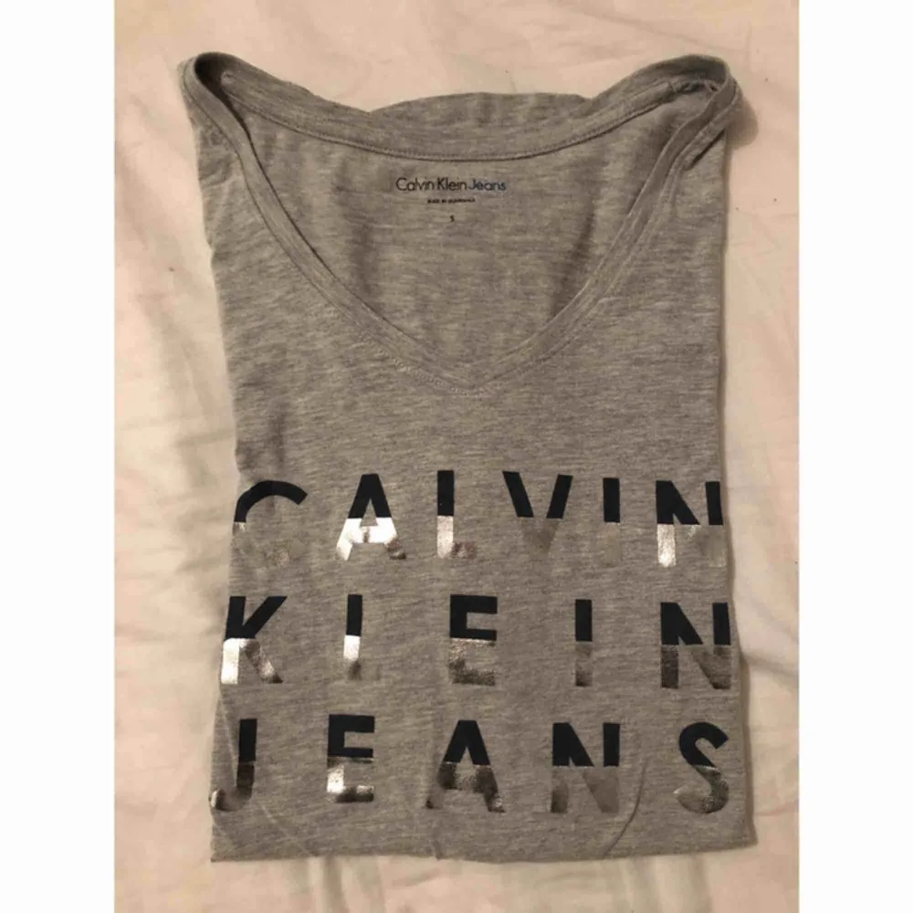 T-shirt med Calvin Klein tryck. Halva bokstäverna är glittriga/glansiga. Passar den som har storlek M också.. T-shirts.