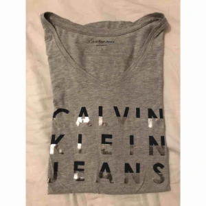  - T-shirt med Calvin Klein tryck. Halva bokstäverna är glittriga/glansiga. Passar den som har storlek M också.