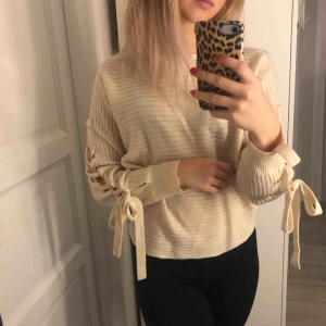  - Krämvit tröja med knytningar längst armen. Använd fåtal gånger.🥰