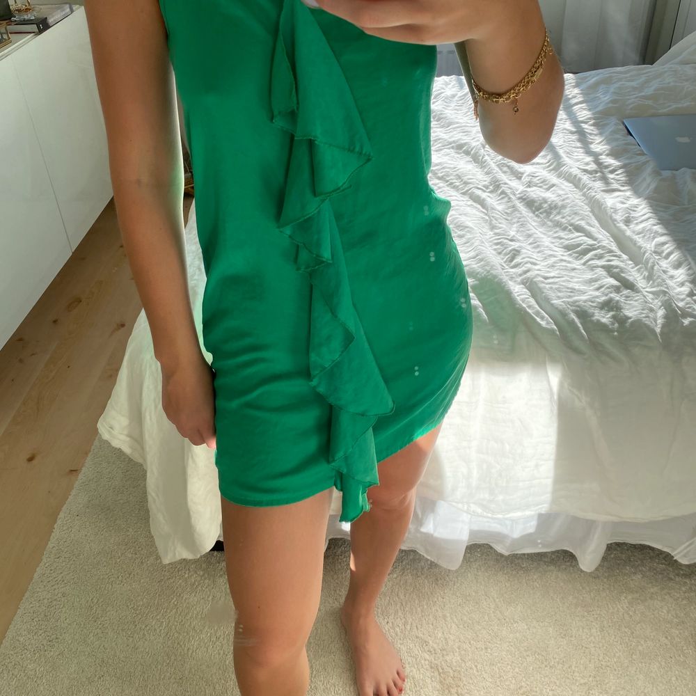 Kort grön klänning med volang framtill ifrån Zara stl. S. Klänningar.