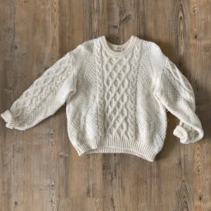 Stickad, vit tröja  - Ett supergulligt plagg av god kvalitét. Köpt i fin butik när jag bodde i Thailand. Har dock fått en grå sotfläck på ena ärmen, men knappt synligt! Väldigt varm, superbra att gosa ned sig i när kylan kommer! 