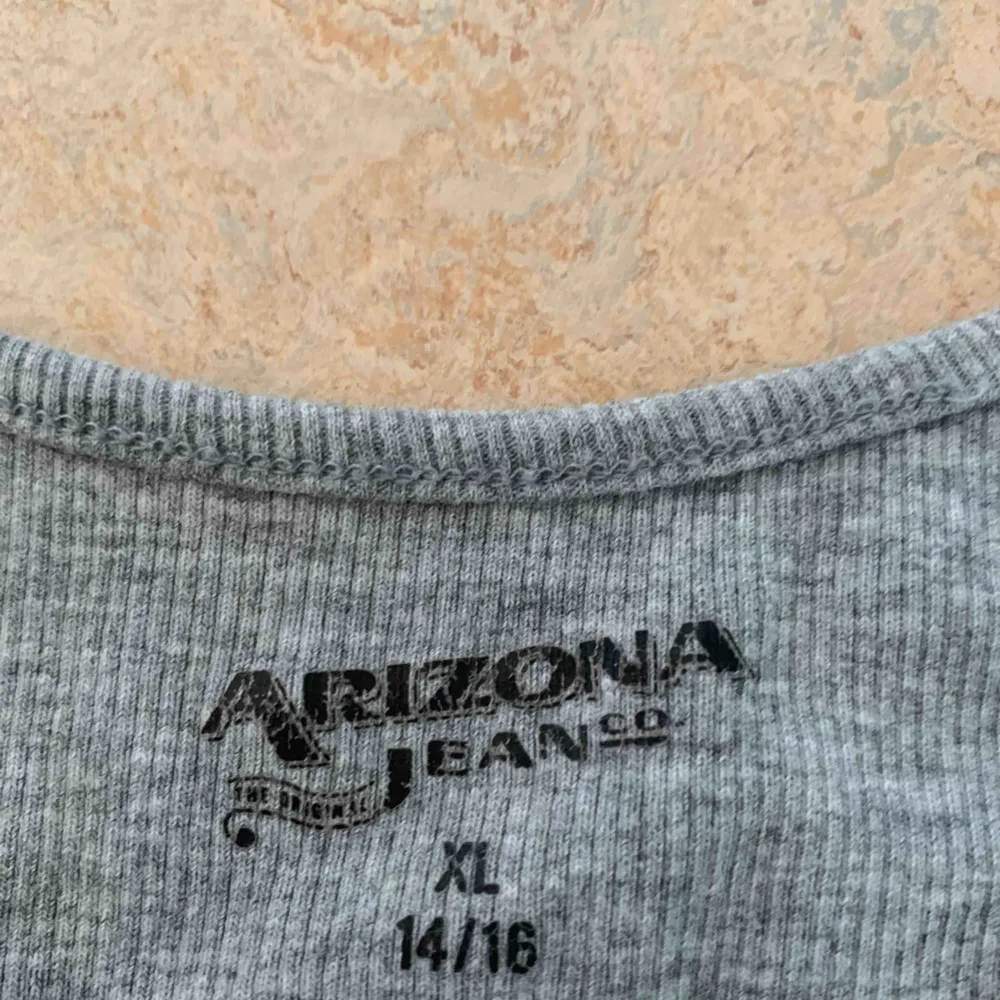 Ett ribbat linne från Arizona i som känns som en stl S men är väldigt stretchig så den kan nå upp till L. Toppar.