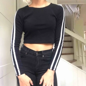  - Snygg svart tajt tröja med streck på ärmarna. Finns några fläckar på höger ärm annars bra skick. Kan fraktas eller bytas.