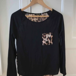  - Snygg svart långärmad tröja med trendigt leopardmönster. Baksidan är i leopard och framsidan är svart med leopardficka. Använd ytterst lite. Snygg till fest!🎉