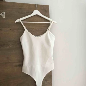  - Tight stringbody! Skulle anse som offwhite/gräddvit. Lite gulnad på axelbanden och insidan av V-ringningen pga solkräm, syns knappt när man har den på sig!  Använd ett par gånger men felfritt skick! 