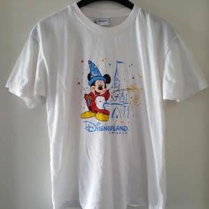  - Vintage vit t -shirt med tryck. Har en pytteliten fläck framtill på sidan av trycket (se bild 2). Står ingen storlek men skulle säga ca som en S. Kan skickas om köparen står för frakten, som då blir 36kr.