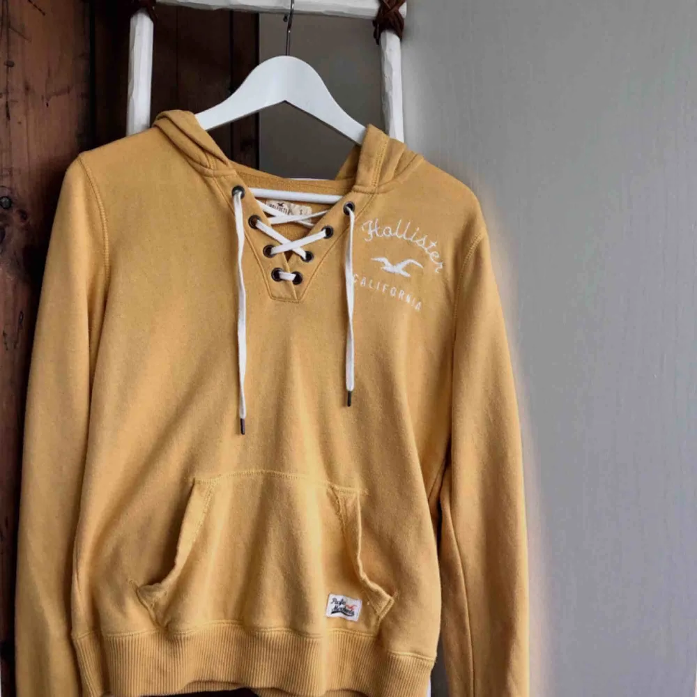 Gul tunnare hoodie från Hollister med snygg snörnings detalj i fram. Den används inte lika mycket som den förtjänar så därför säljer jag den🐝 Köparen står för fraktkostnaden. Hoodies.