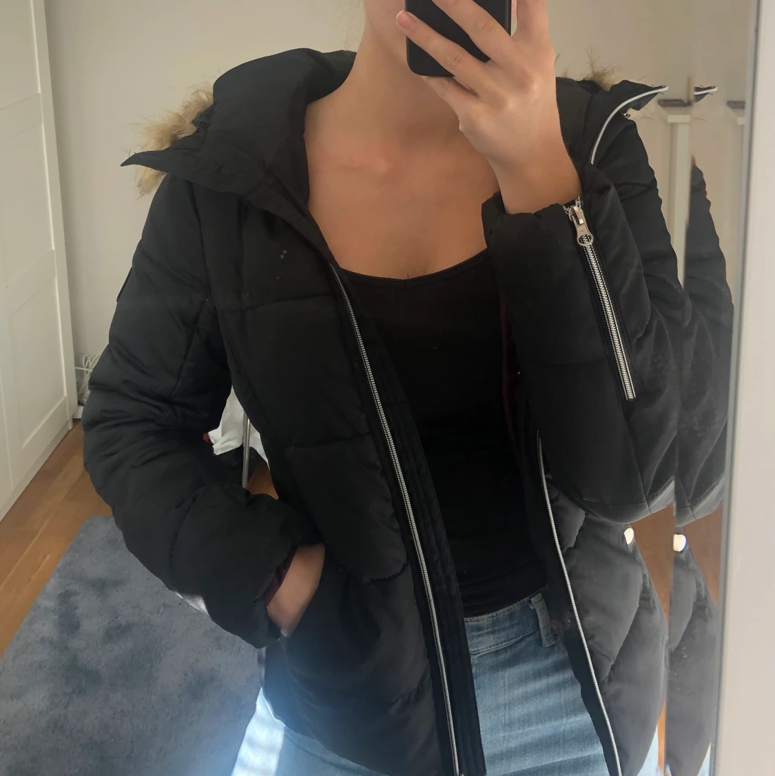 Svart vinterjacka med pälsluva