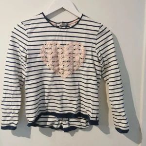 Randig långärmad tröja - En randig tröja som är sällan använd. På den finns en liten fläck som visas på en av bilderna men priset är lågt pga detta. Sen står det även ett namn på en namnlapp innanför tröjan. Tröjan är såklart tvättad från senaste användning 