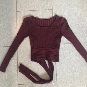 Zara croppad tröja  - Super fin croppad tröja i vinrött. Knytning bak i ryggen som går att styla