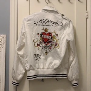 Ed Hardy vindjacka - Jättefin ed Hardy jacka som inte kommer till användning, ett litet hål i ryggen som inte spelar så stor roll eftersom det inte syns utifrån, går ju att sy igen också. bara att ställa frågor om ni undrar något eller vill ha mer bilder💕. Om flera är intresserade blir det bud💕💕 nu ligger budet på 250