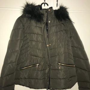 Höst/vinter jacka storlek S - Den är väldigt fin skick och har aldrig använts bara nu när jag tog bild med den. Den är i en väldigt vacker mörkgrön färg. Jätte fin färg och kedjorna fungerar perfekt, som ni kan se två fickor. Men guldfärgade kedjor.